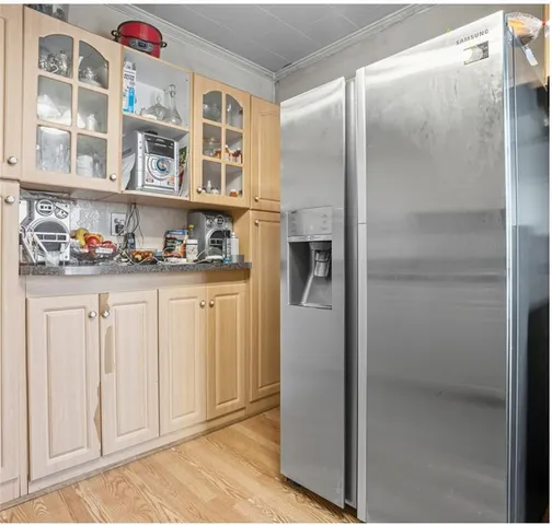 a kitchen with granite countertop a refrigerator and cabinets