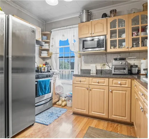 a kitchen with stainless steel appliances granite countertop a refrigerator a stove and a sink with cabinets