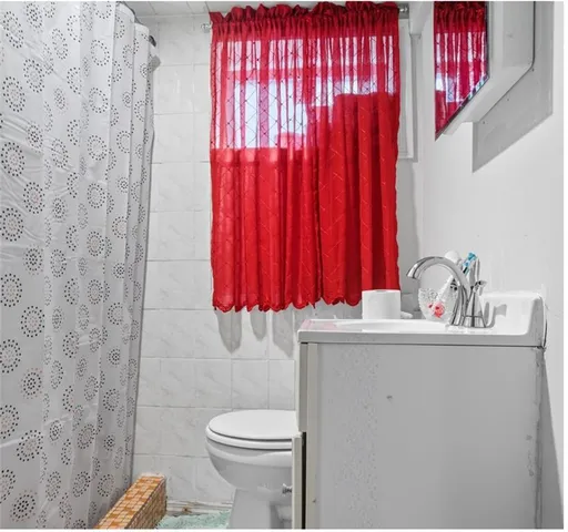 a bathroom with a sink a toilet and shower curtain