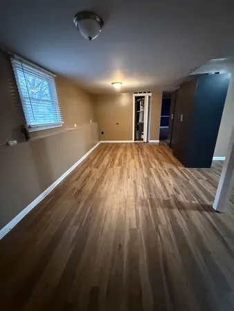 a view of empty room with wooden floor