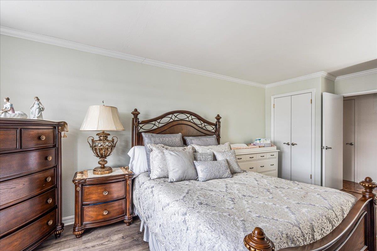 17-85 215th Street, Unit 16J Queens, NY 11360 - Photo 15 of 28 a bedroom with a bed and dresser