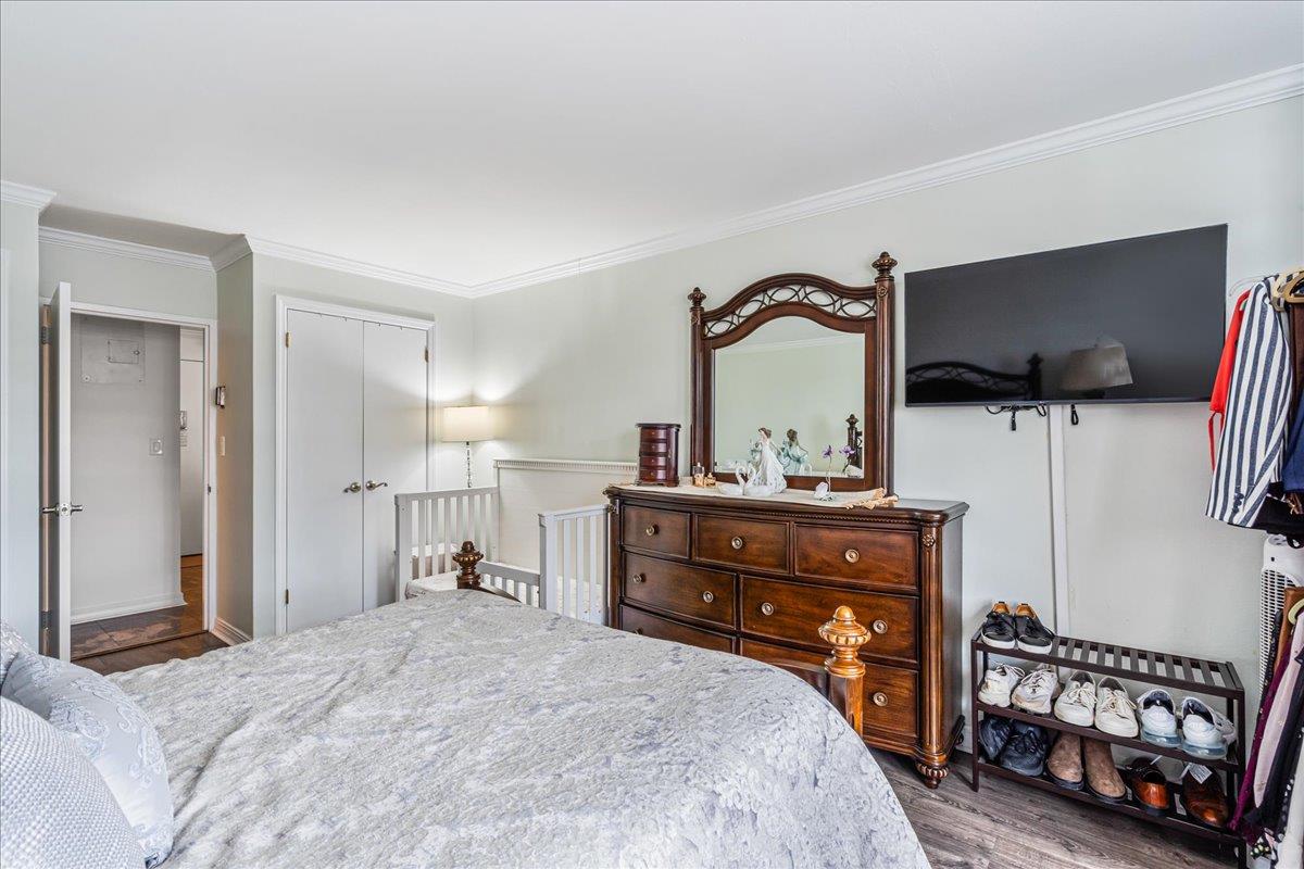 17-85 215th Street, Unit 16J Queens, NY 11360 - Photo 16 of 28 a bedroom with a bed and a flat screen tv