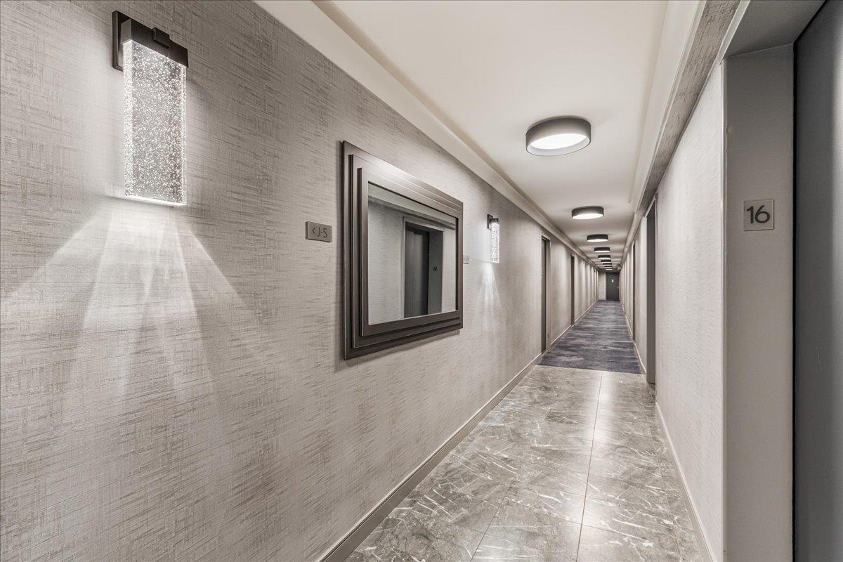 17-85 215th Street, Unit 16J Queens, NY 11360 - Photo 17 of 28 a view of a hallway with wooden floor and staircase