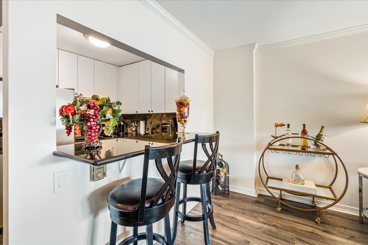17-85 215th Street, Unit 16J Queens, NY 11360 - Photo 2 of 28 a very nice looking dining room with chandelier fan and wooden floor