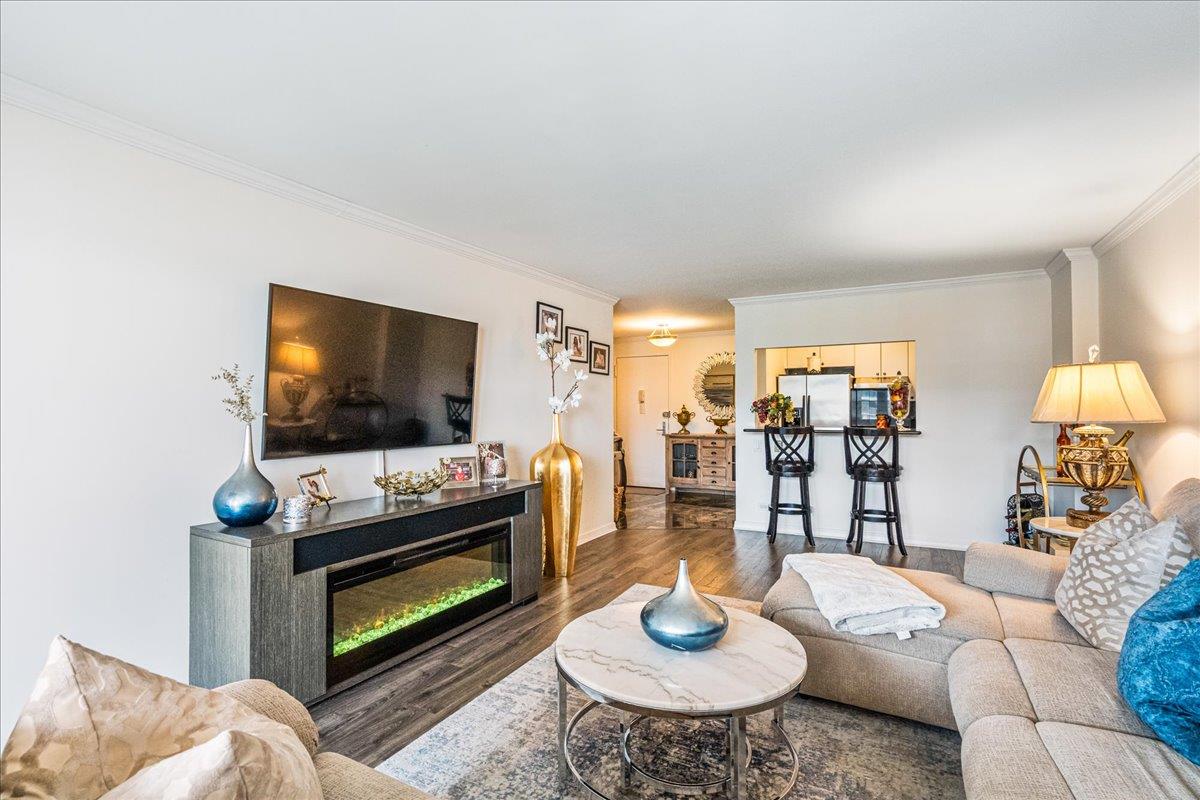 17-85 215th Street, Unit 16J Queens, NY 11360 - Photo 6 of 28 a living room with furniture and a flat screen tv