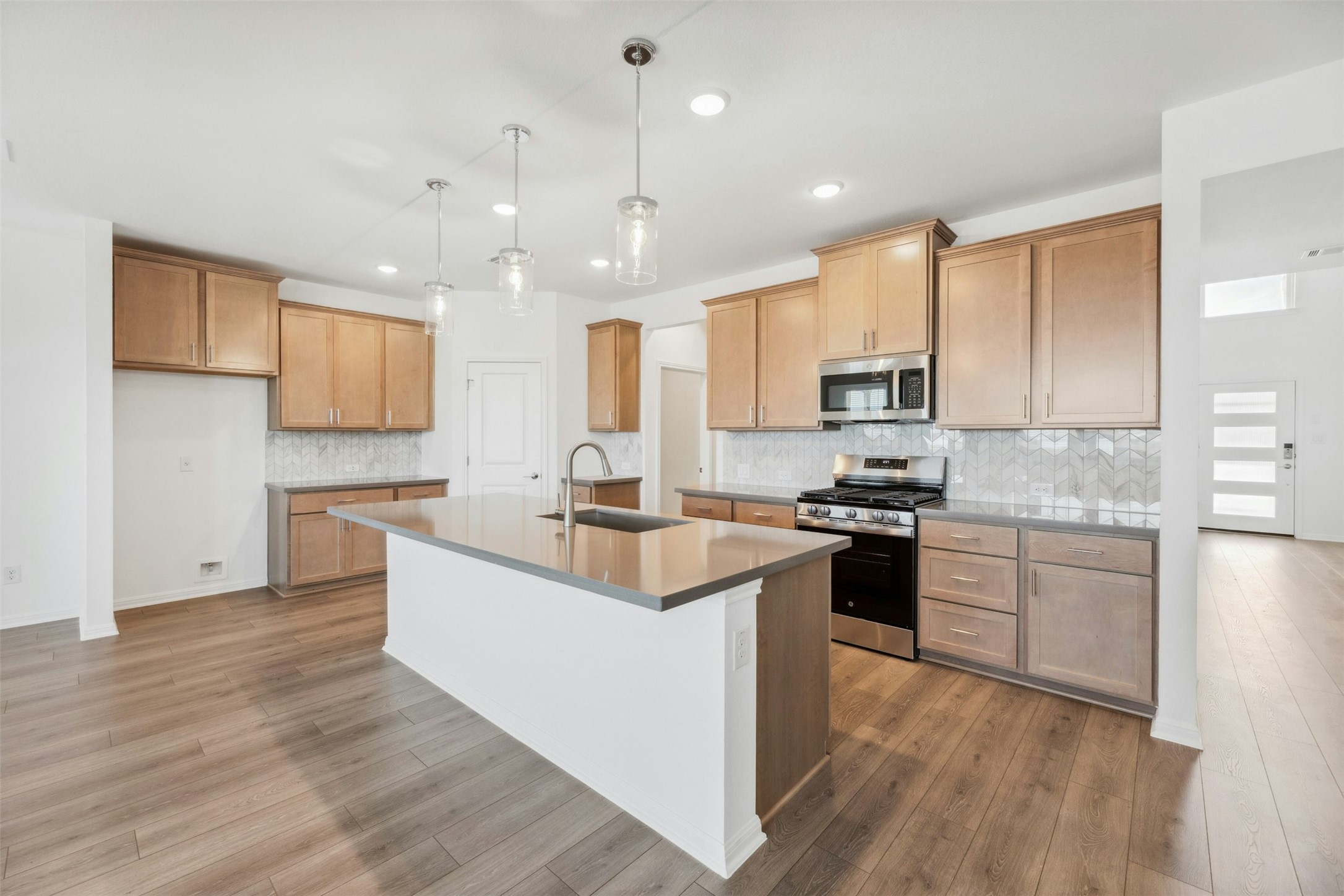 2001 Wynn Road Hutto, TX 78634 - Photo 8 of 39 A pristine culinary space with an inviting island and elegant wooden flooring.