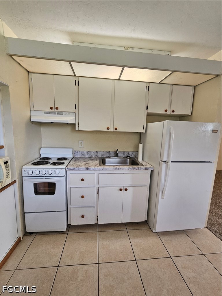 8101 Country Road, Unit 201 Fort Myers, FL 33919 - Photo 8 of 34 a kitchen with cabinets and white appliances