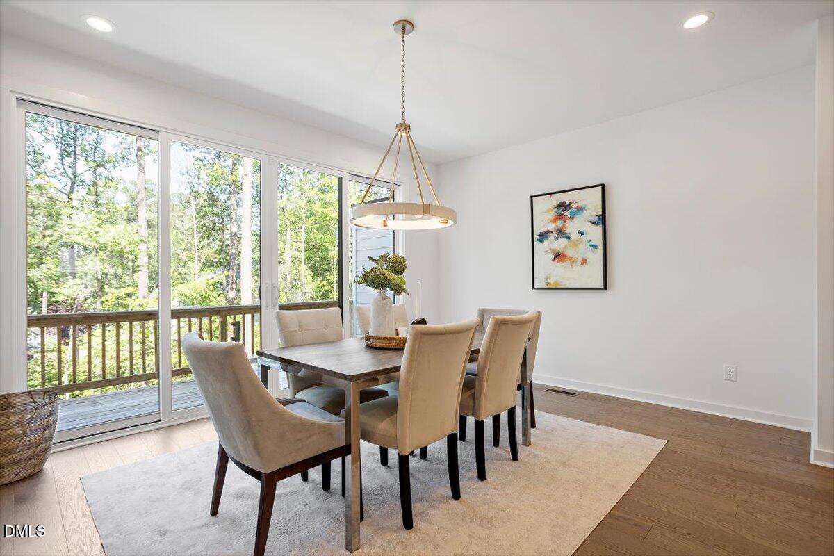 6419 Tanner Oak Lane Raleigh, NC 27613 - Photo 17 of 39 a dining room with furniture a chandelier and wooden floor