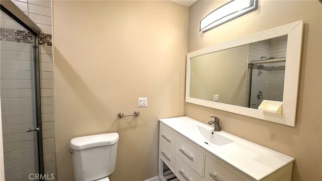 a bathroom with a sink mirror vanity and toilet
