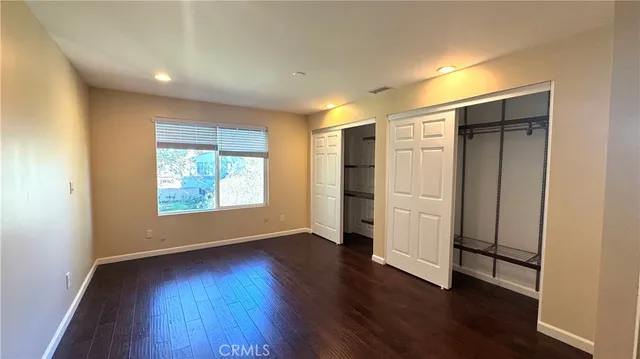 a view of empty room with wooden floor and window