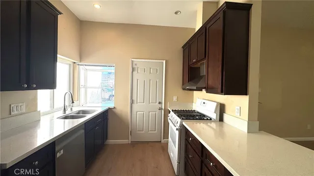 a kitchen with granite countertop a sink stove and cabinets