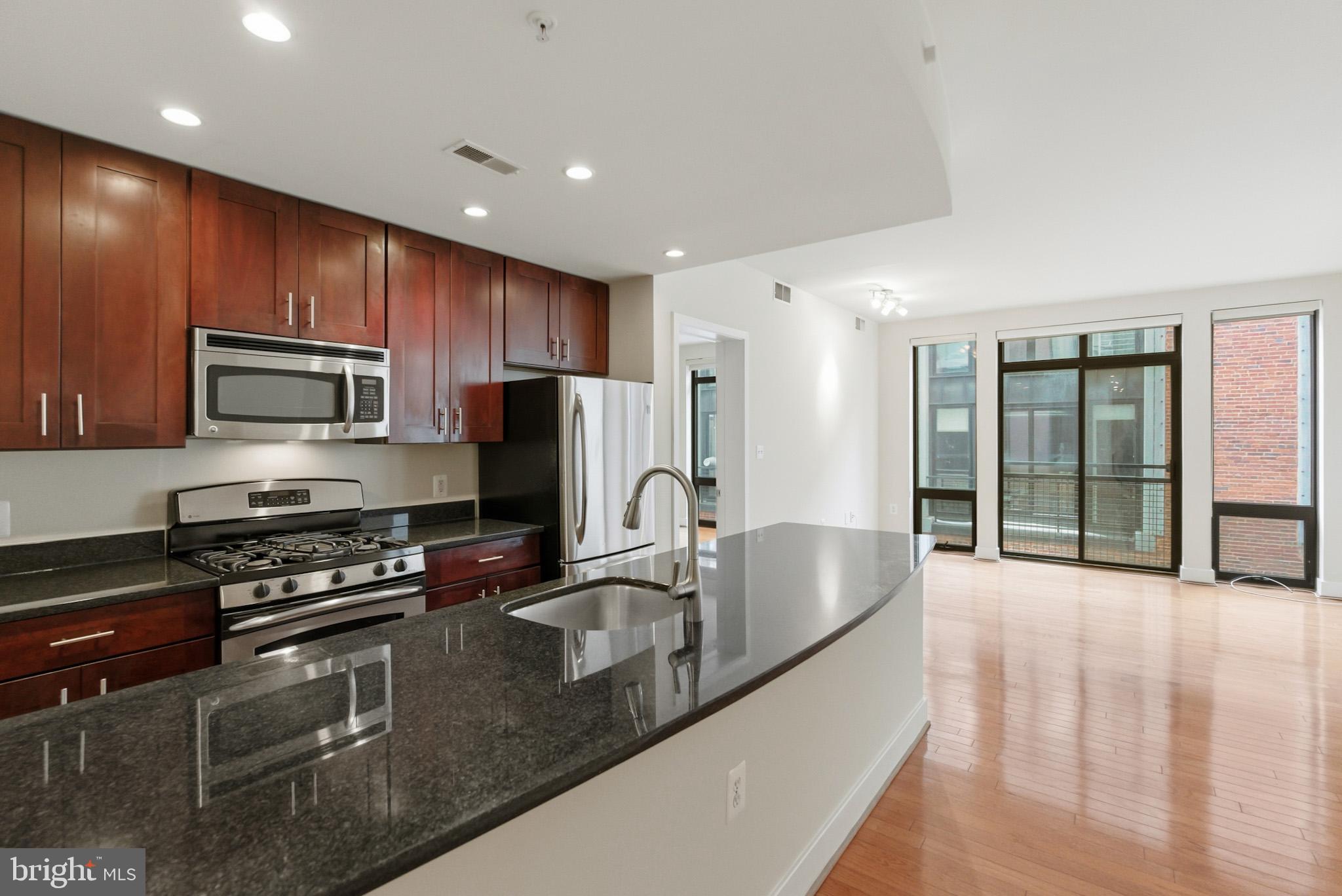 1211 13th Street Northwest, Unit 206 Washington, DC 20005 - Photo 1 of 22 a kitchen with granite countertop a stove a sink and a refrigerator
