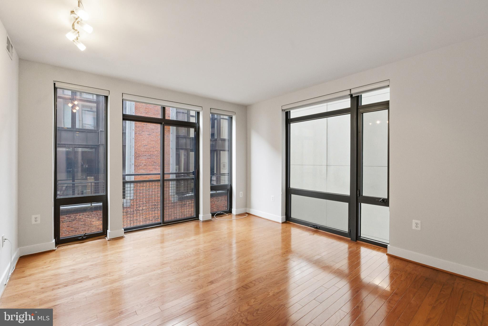 1211 13th Street Northwest, Unit 206 Washington, DC 20005 - Photo 3 of 22 an empty room with wooden floor and sliding door