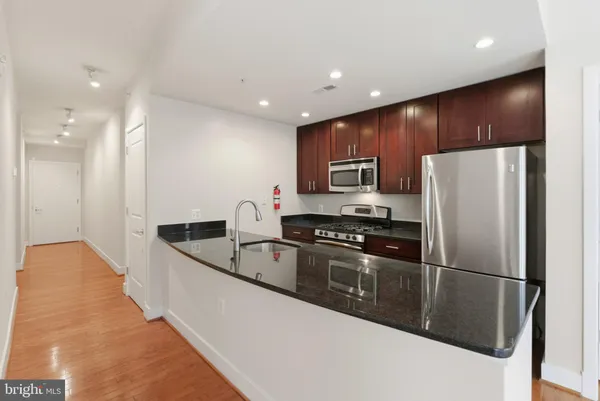 a kitchen with stainless steel appliances granite countertop a refrigerator and a stove top oven