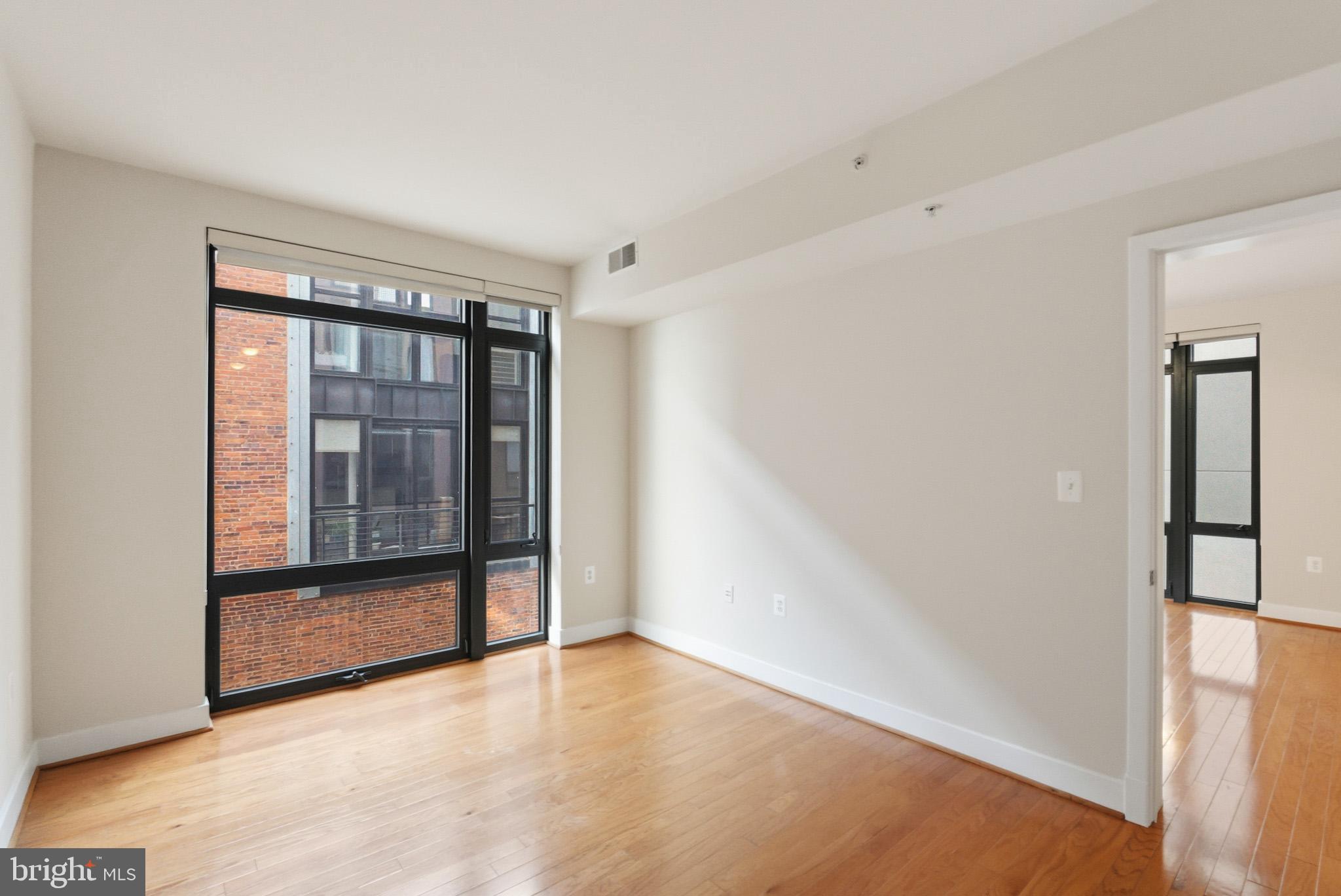 1211 13th Street Northwest, Unit 206 Washington, DC 20005 - Photo 9 of 22 a view of empty room with wooden floor and fan