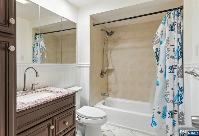 a bathroom with a granite countertop sink a toilet and a bathtub