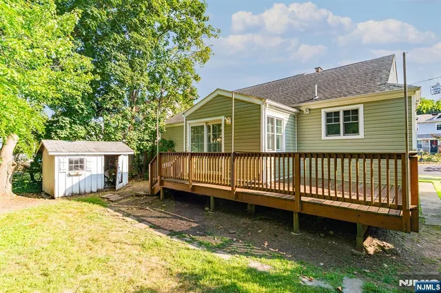 a view of a house with a yard chairs and wooden fence