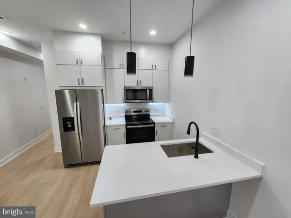 a kitchen with stainless steel appliances a refrigerator sink and stove