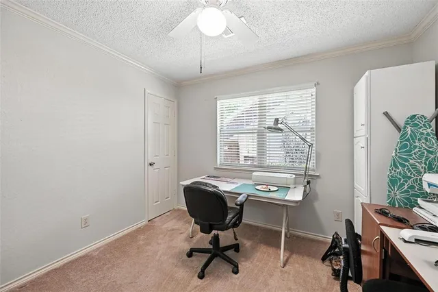 a view of a workspace with furniture and a window