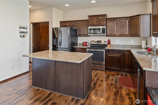 a kitchen with granite countertop a refrigerator stove and sink