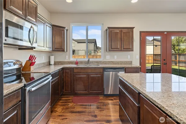 a kitchen with stainless steel appliances granite countertop a sink stove and cabinets