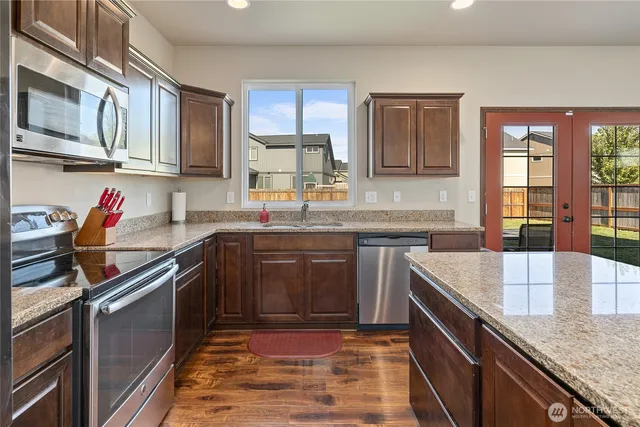 a kitchen with stainless steel appliances granite countertop a sink stove and cabinets