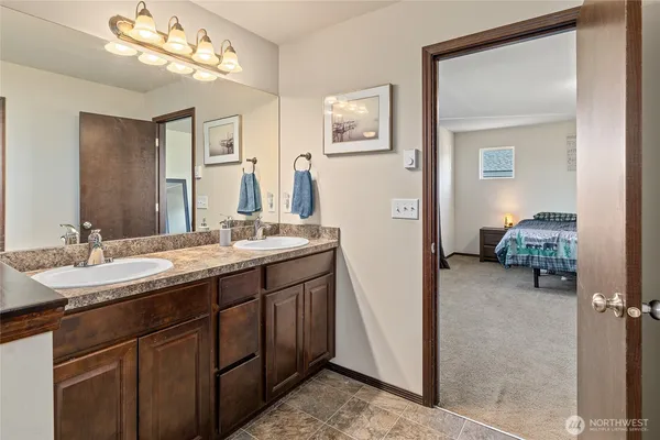 a en suite bathroom with a double vanity sink and a mirror