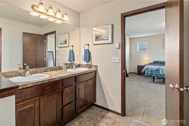 a en suite bathroom with a double vanity sink and a mirror