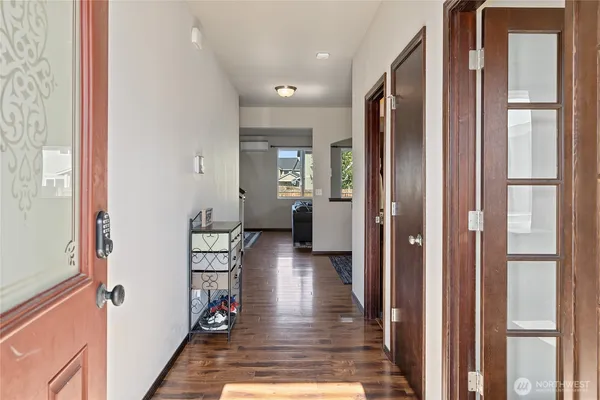 a hallway with wooden floor furniture and front door