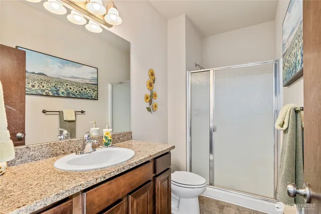 a bathroom with a granite countertop sink toilet and shower