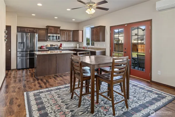 a kitchen with stainless steel appliances granite countertop a dining table and chairs