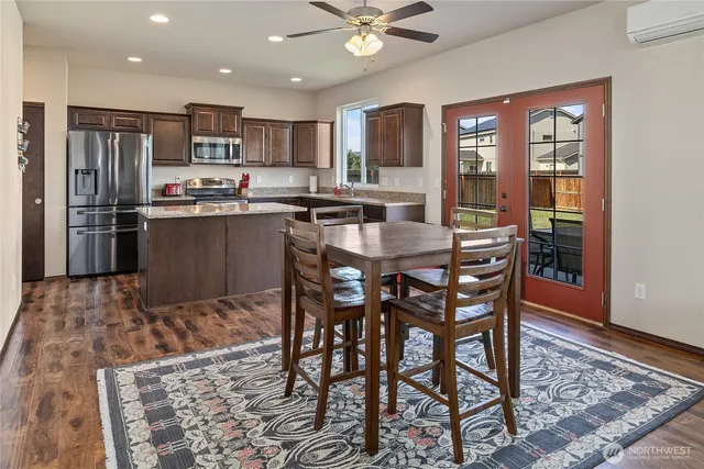 a kitchen with stainless steel appliances granite countertop a dining table and chairs