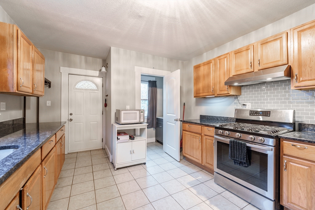 71 Daviston Street Springfield, MA 01108 - Photo 11 of 32 a kitchen with stainless steel appliances granite countertop a stove a sink and a refrigerator