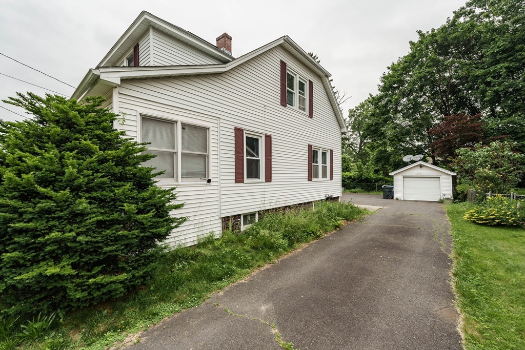 71 Daviston Street Springfield, MA 01108 - Photo 4 of 32 a view of a white house with a small yard and a large tree