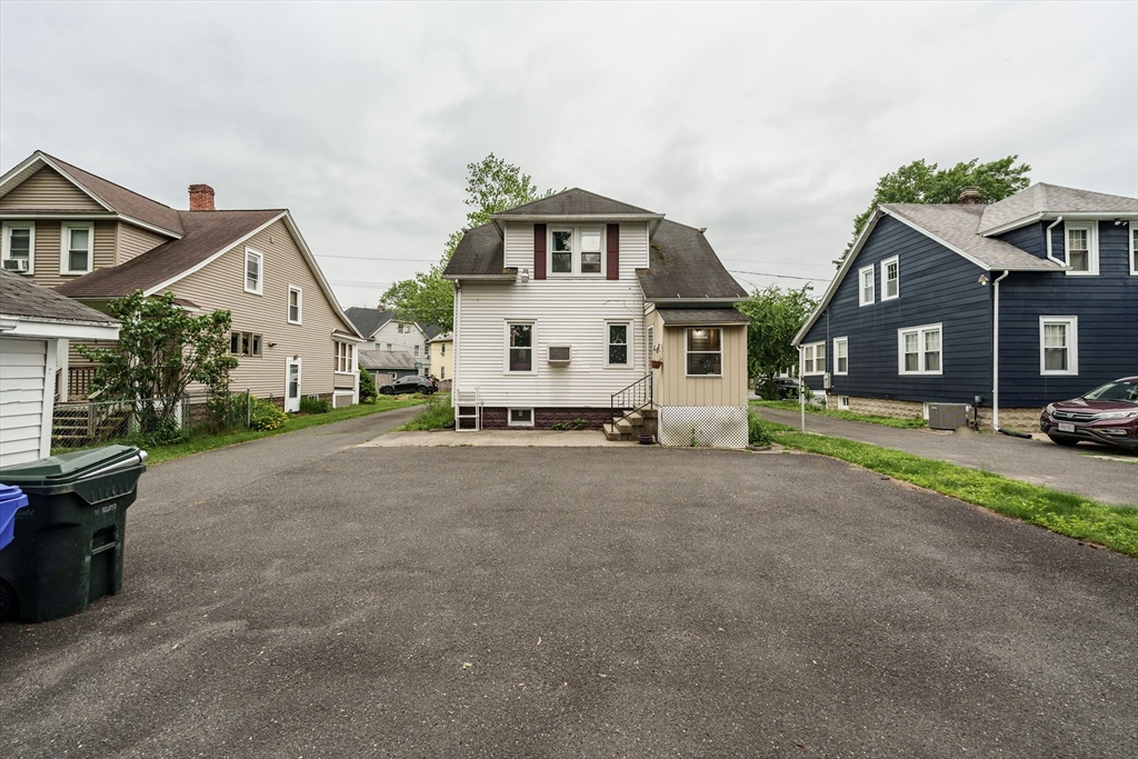 71 Daviston Street Springfield, MA 01108 - Photo 5 of 32 a view of a white house next to a yard with big trees