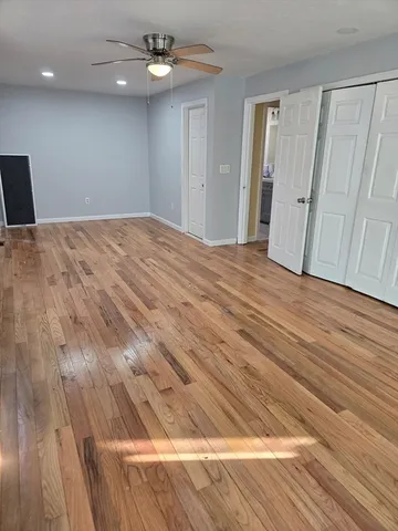 a view of empty room with wooden floor