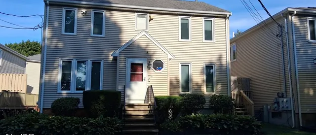 a view of a house with a yard and potted plants