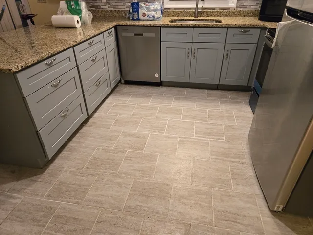 a kitchen with granite countertop a sink a stove top oven cabinets and a counter top space