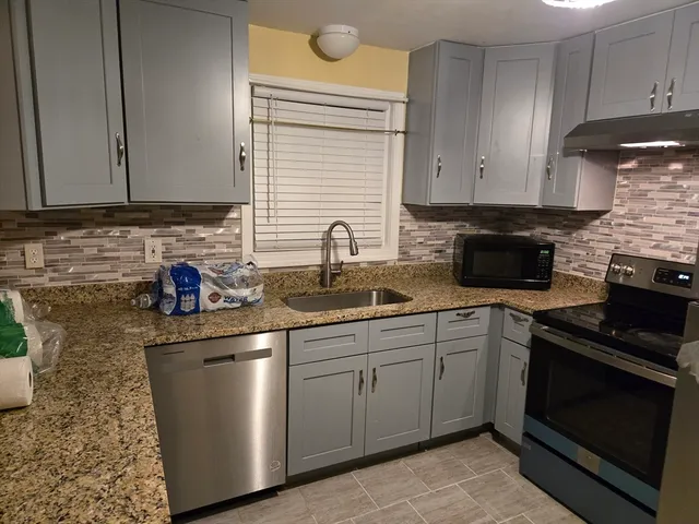 a kitchen with sink a microwave and cabinets