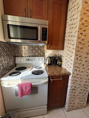a kitchen with stainless steel appliances wooden cabinets and a stove top oven