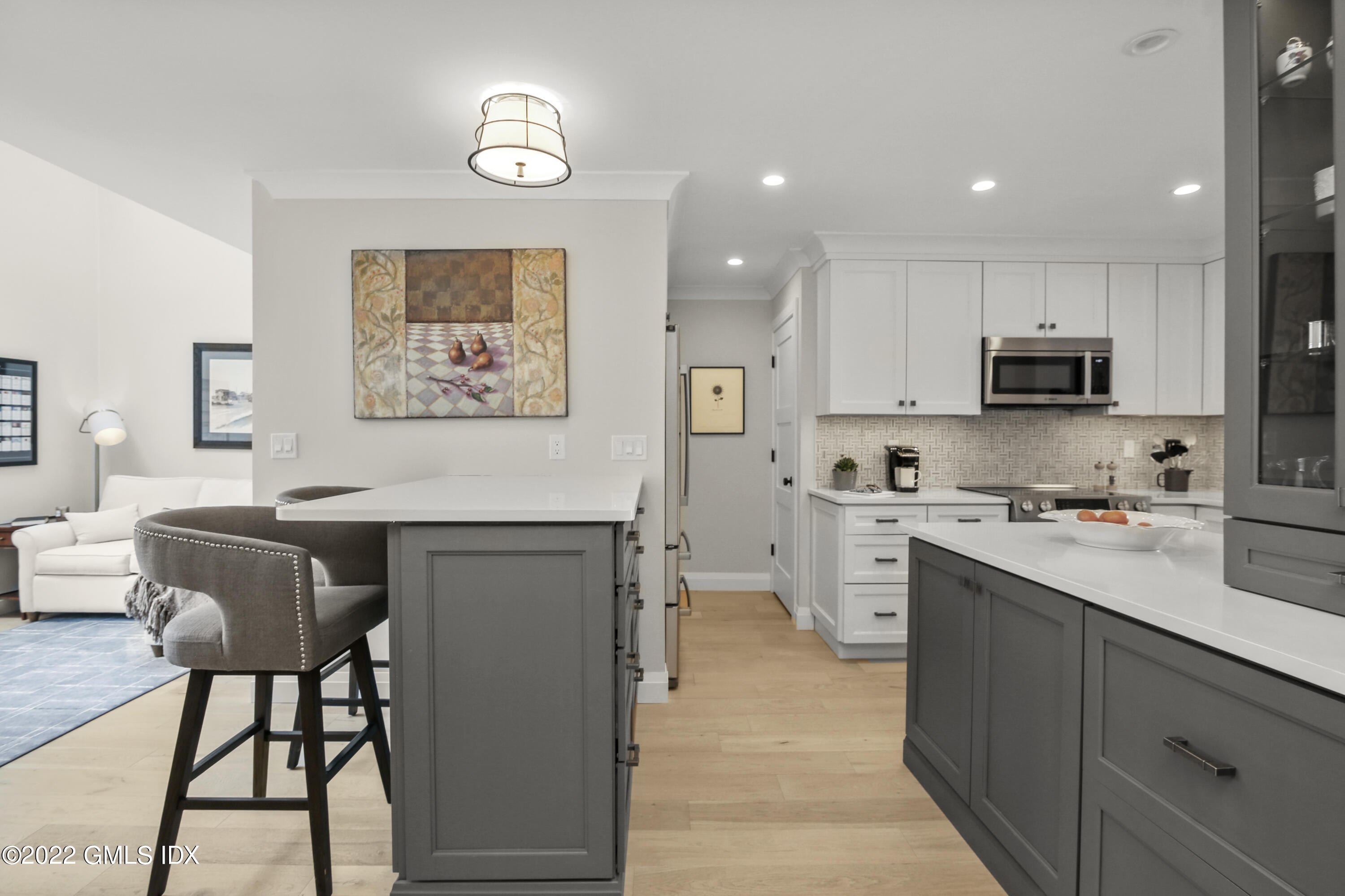 15 River Road, Unit 213 Cos Cob, CT 06807 - Photo 5 of 20 a kitchen with a refrigerator a stove top oven a sink dishwasher and white cabinets with wooden floor