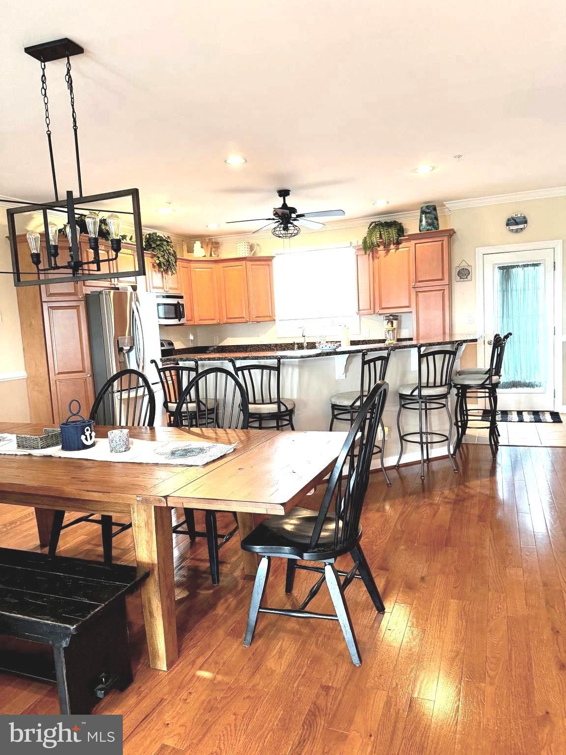 9823 Golf Course Road, Unit 20 Ocean City, MD 21842 - Photo 15 of 61 a view of a dining room with furniture and wooden floor