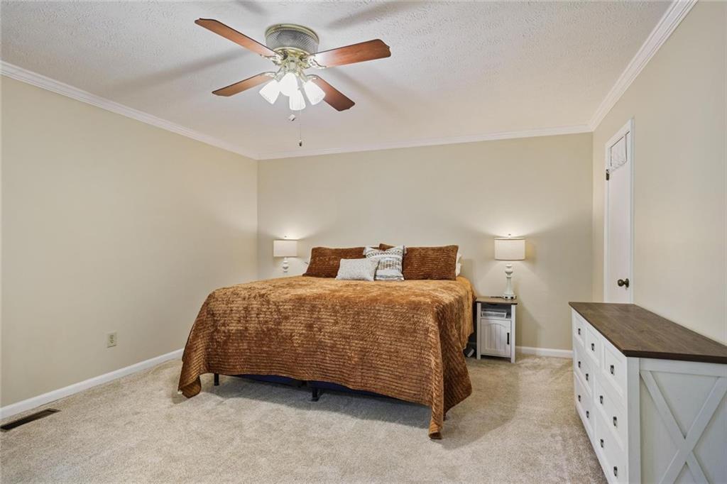 4505 Cochran Mill Road Fairburn, GA 30213 - Photo 21 of 36 a bedroom with a bed and a ceiling fan