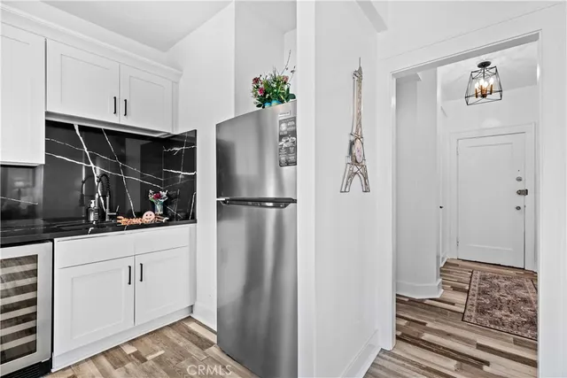 a kitchen with white cabinets and refrigerator