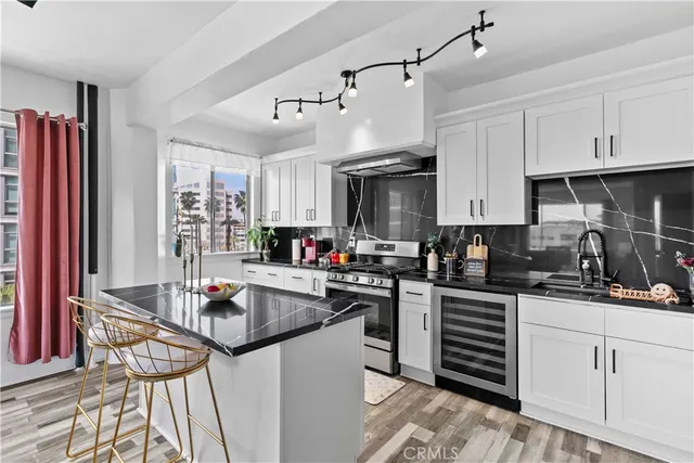 a kitchen with granite countertop a sink stainless steel appliances and cabinets