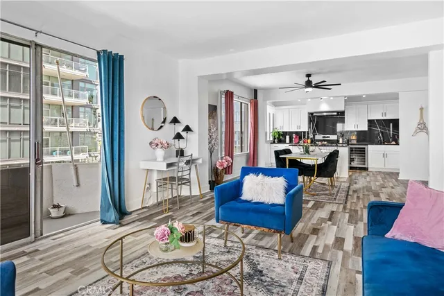 a living room with furniture a rug and kitchen view