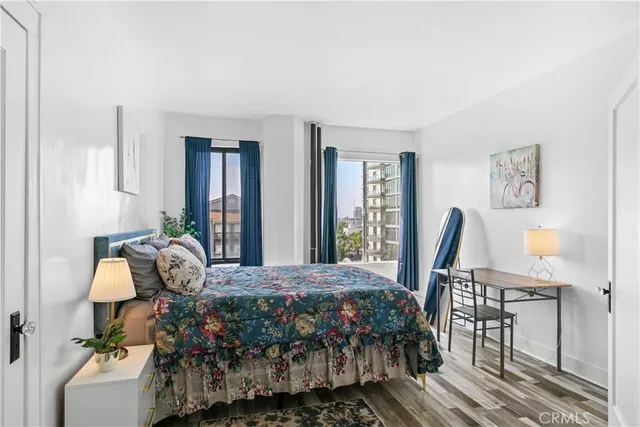 a bedroom with a bed and large windows