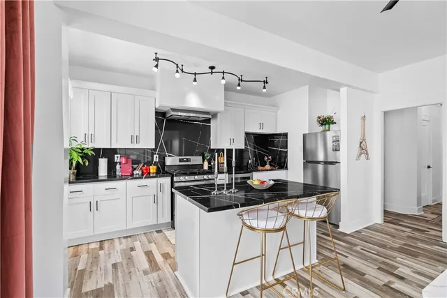 a kitchen with granite countertop a sink stove and refrigerator