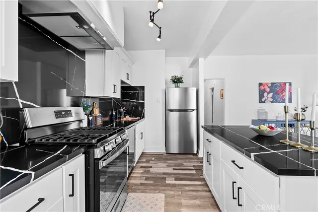 a kitchen with stainless steel appliances a sink stove and refrigerator