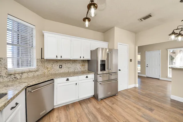 a kitchen with white cabinets and white appliances
